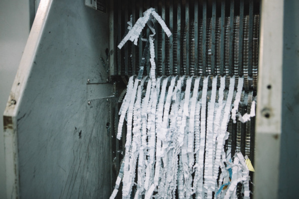 Shredding machine showing thin strips of crinkled paper post-shred
