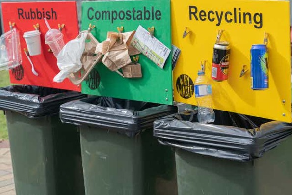 an example of recycling sorting stations with real examples taped above each bin